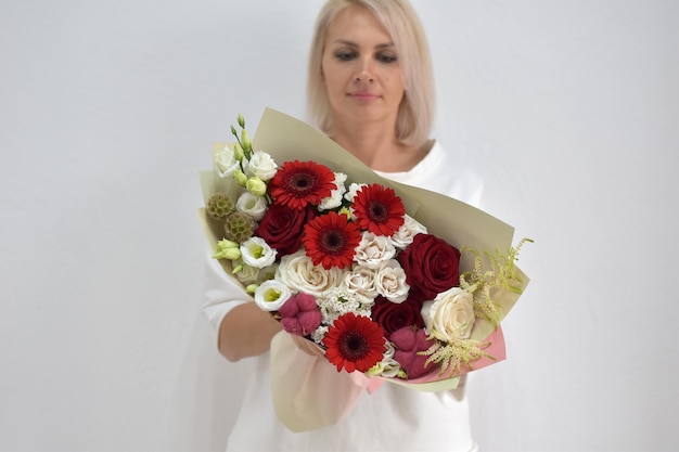 Beau bouquet de fleurs dans les mains d'une femme photo pour carte postale et catalogue d'un fleuriste en ligne livraison de fleurs fraîches