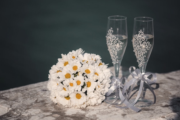 Beau bouquet de fleurs fraîches et deux verres de champagne