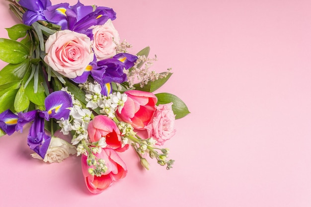Un beau bouquet de fleurs fraîches sur une surface pastel rose