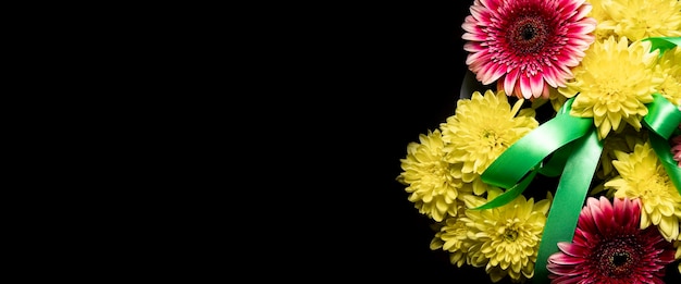 Beau bouquet de fleurs jaunes et roses sur fond noir Bannière