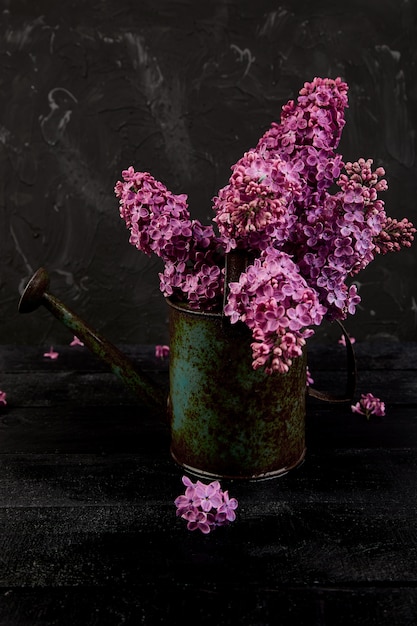 Beau bouquet de fleurs lilas dans un arrosoir en métal