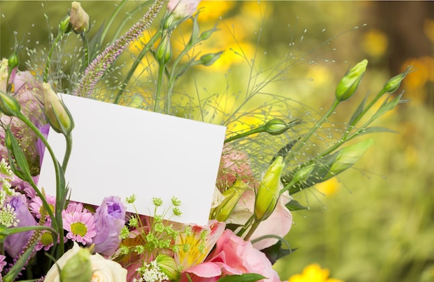 Photo beau bouquet de fleurs de lys et carte vierge sur fond