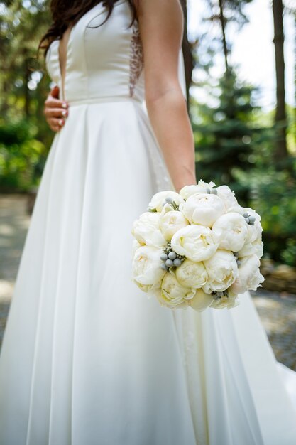 Beau bouquet de fleurs de mariage dans les mains des jeunes mariés