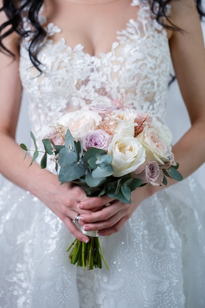 Beau bouquet de fleurs de mariage dans les mains des jeunes mariés