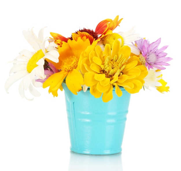 beau bouquet de fleurs sauvages brillantes dans un seau métallique bleu isolé sur blanc