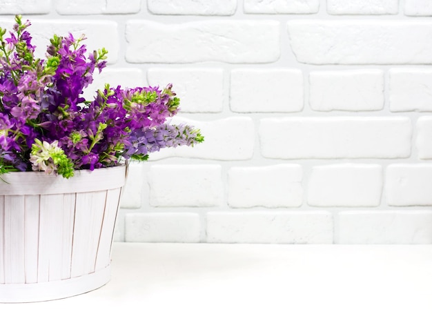 Beau bouquet de fleurs violettes lilas dans un panier blanc sur fond blanc Carte de voeux fête des mères Place pour une inscription