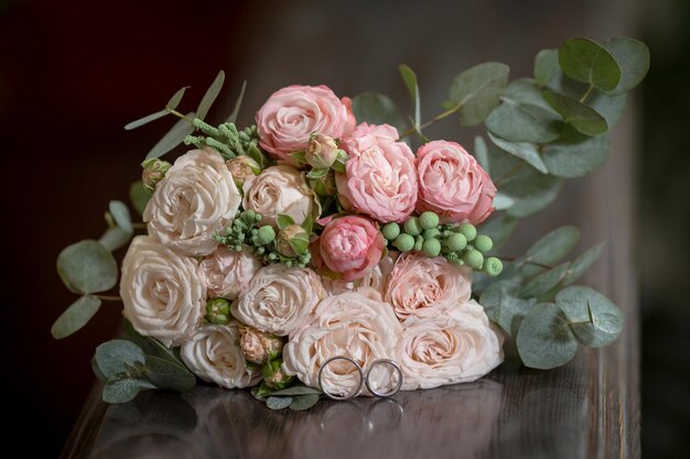 Beau bouquet de mariage avec des anneaux de mariage sur une table en bois photo de haute qualité