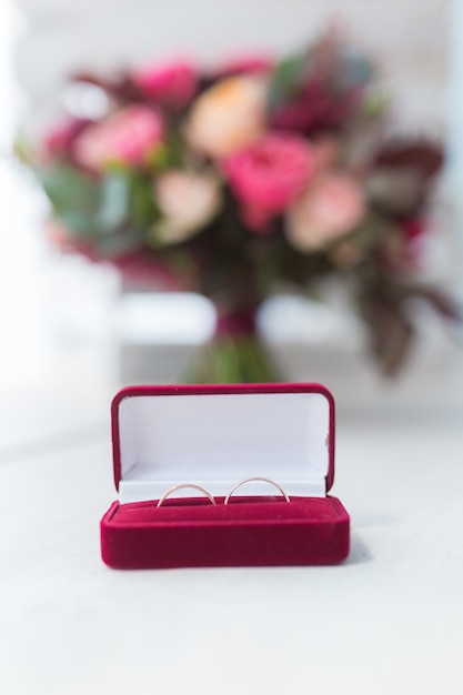 Beau bouquet de mariage et anneaux d'or dans la boîte rouge