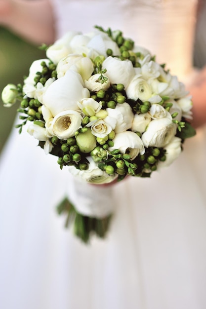 Beau bouquet de mariage blanc dans la main de la mariée