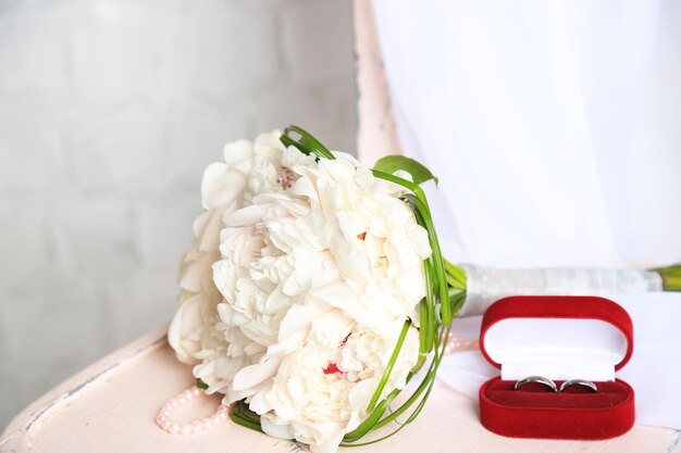 Beau bouquet de mariage sur une chaise en bois sur fond clair