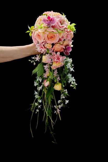 Beau bouquet de mariage élégant dans une main de la femme sur fond noir