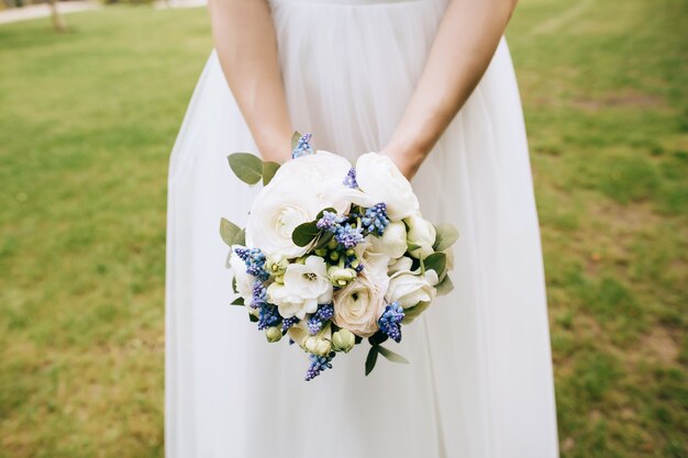 Beau bouquet de mariage de pivoines blanches dans les mains de la mariée