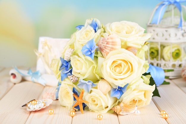 Beau bouquet de mariage avec des roses sur table en bois, sur fond de nature