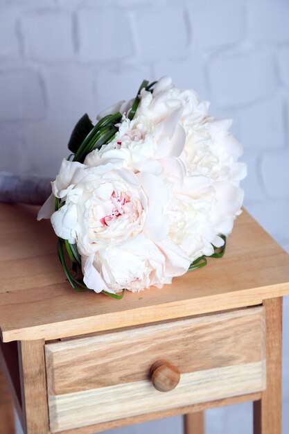 Beau bouquet de mariage sur support en bois sur fond de mur clair