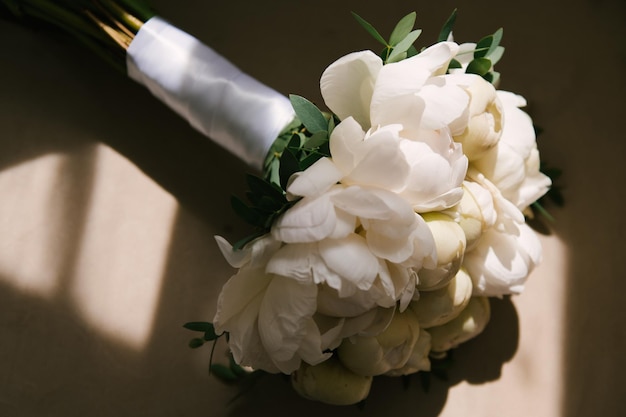 Beau bouquet de mariée blanc de pivoines aux rayons du soleil