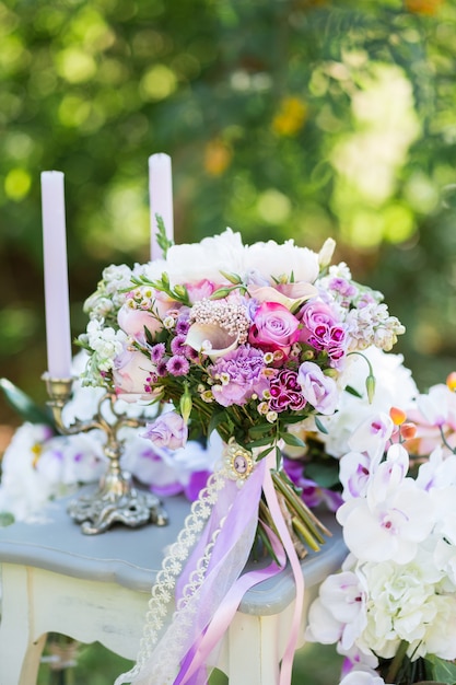 Beau bouquet de mariée coloré de différentes fleurs et décoration de mariage sur la nature