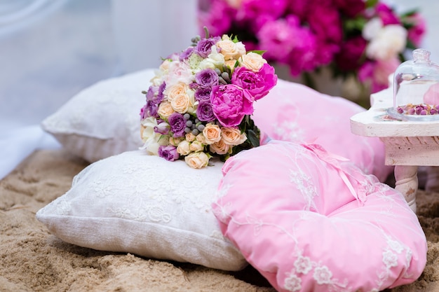 Beau bouquet de mariée délicat parmi les décorations avec oreiller