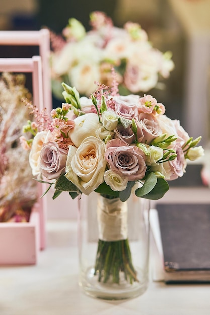 Beau bouquet de mariée avec des roses debout sur la table