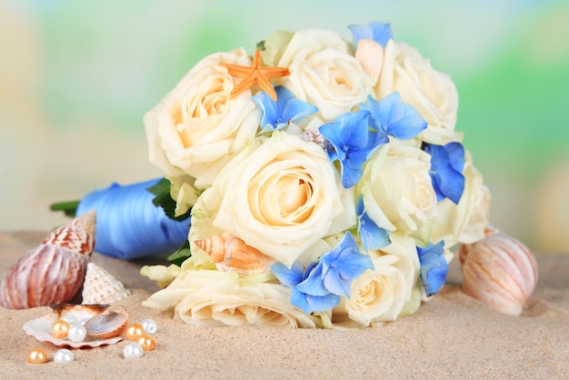 Beau bouquet de mariée avec des roses sur le sable, sur fond de nature