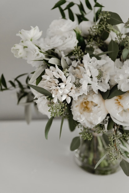 Un beau bouquet de mariée se trouve dans un vase d'eau.