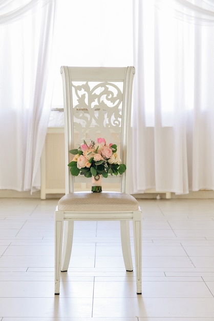 Photo beau bouquet de mariée tendre de roses est sur la chaise