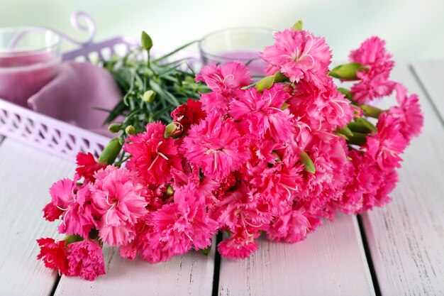 Beau bouquet d'oeillet rose sur table en bois se bouchent