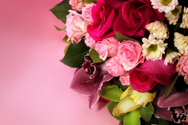 Beau bouquet de printemps de gros plan de fleurs sur fond rose. Bouquet de roses, chrysanthèmes, lys.