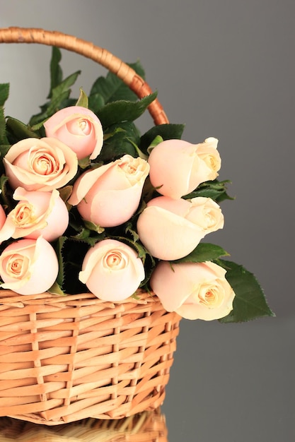 Beau bouquet de roses dans le panier sur fond gris