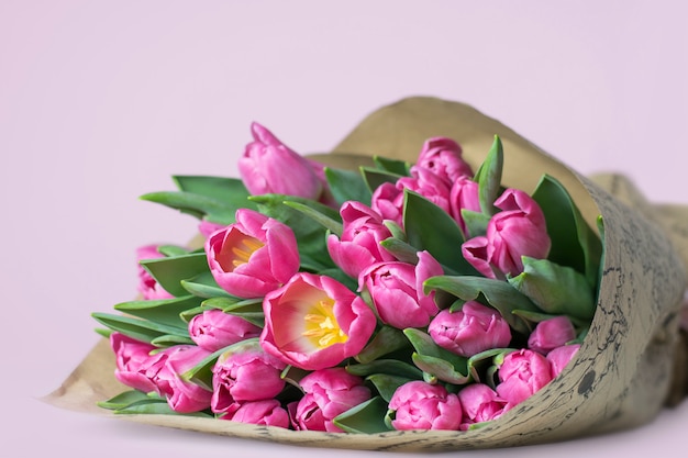 Un beau bouquet de tulipes roses sur fond rose