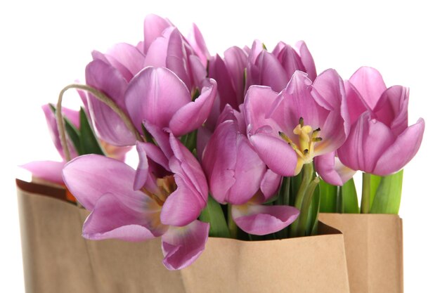 Beau bouquet de tulipes violettes dans un sac en papier, isolé sur blanc