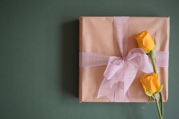 Un beau cadeau et deux roses jaunes sur fond noir