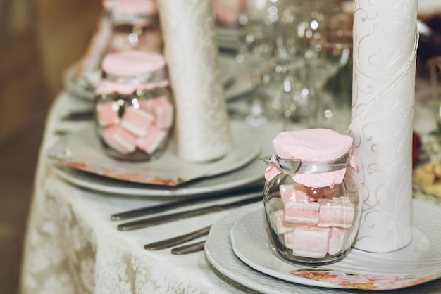 Photo beau cadre décoré sur une table de pièce maîtresse avec des verres et des couverts élégants lors d'une réception de mariage de luxe dans un restaurant