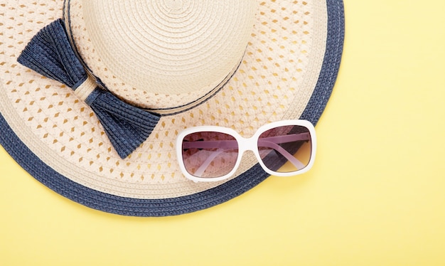 Beau chapeau de paille avec arc et lunettes de soleil isolés