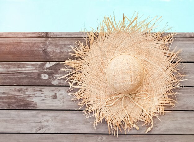 Photo beau chapeau de paille féminin allongé près de la piscine