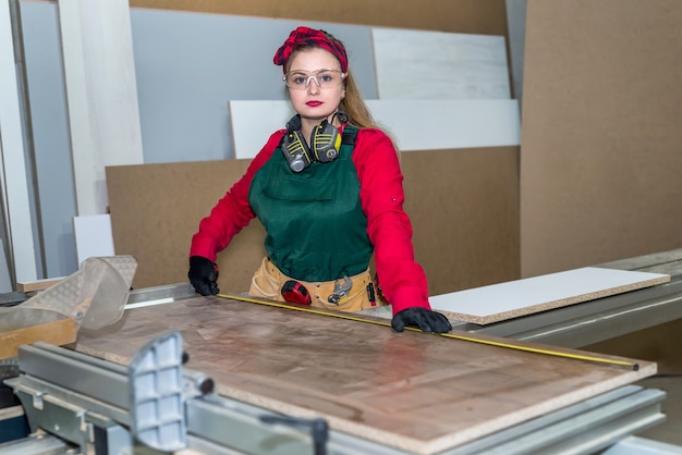 Beau charpentier faisant des mesures de planche de bois