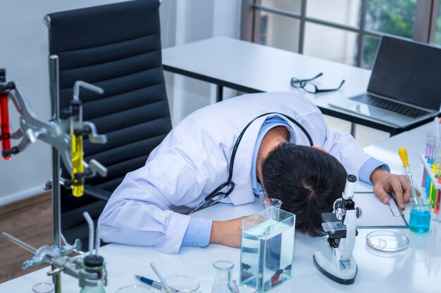 Beau Chercheur Travaillant Des Heures Supplémentaires Et Travaillant à Proximité D'instruments De Laboratoire