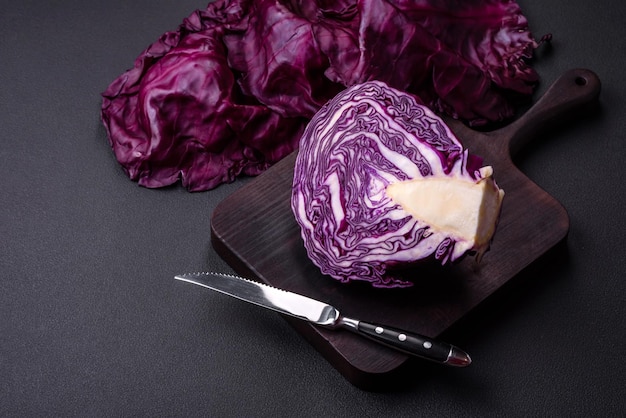 Beau chou rouge frais avec des feuilles texturées sur un fond de béton foncé Cuisine végétarienne