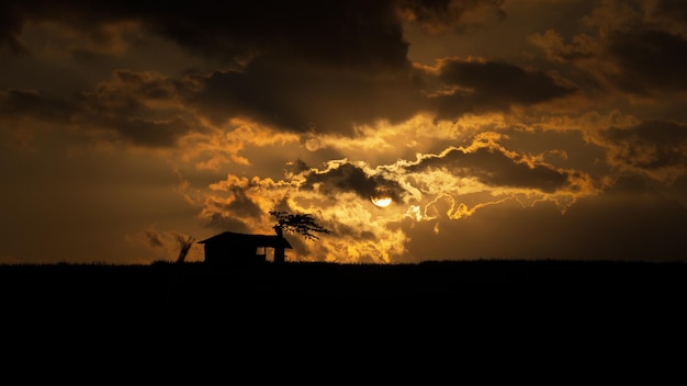 Beau ciel au coucher du soleil avec Cottage Silhouette