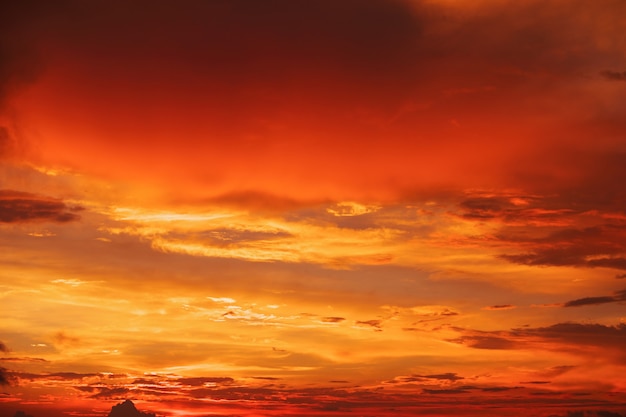 Photo beau ciel lumineux et coloré. photo prise au coucher du soleil. fond rouge-orange avec de belles peintures. rare lever de soleil. composition naturelle