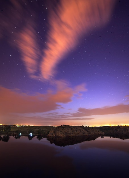 Beau ciel nocturne à la rivière avec des étoiles et des nuages