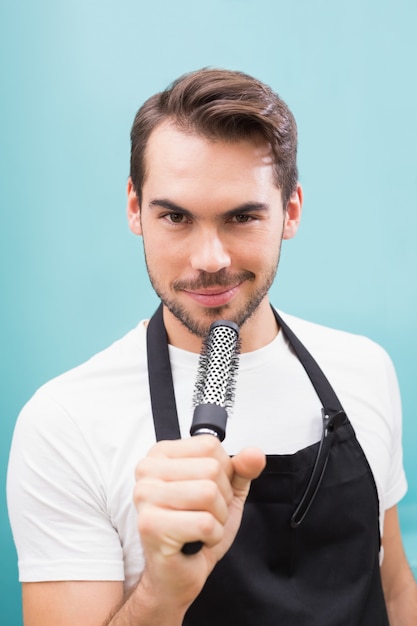 Beau coiffeur souriant à la caméra