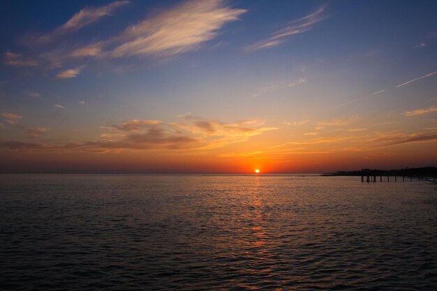 Beau et coloré coucher de soleil lumière chaude et de nombreux nuages vagues de la mer sur la côte de la mer