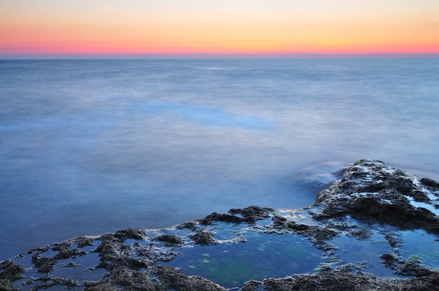 Beau coucher de soleil sur la côte rocheuse de la mer Noire orageuse orageuse en Crimée le jour d'été