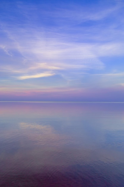 Beau coucher de soleil sur les couleurs pastel de la mer et reflets sur le paysage naturel de l'eau avec des nuages colorés