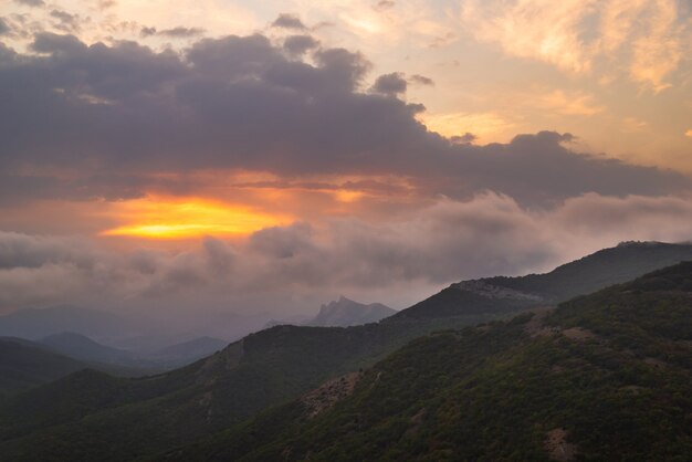 Beau coucher de soleil dans les montagnes verdoyantes, temps nuageux, paysage magnifique