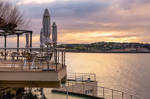 Beau coucher de soleil depuis une terrasse en bord de mer pour profiter de la vue sur la nature Gijon Asturias