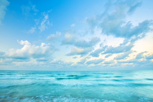 Beau coucher de soleil dessus et vague de la mer sur la plage de sable l&#39;horizon