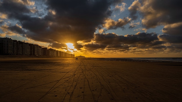 Beau coucher de soleil doré sur la plage avec un ciel nuageux