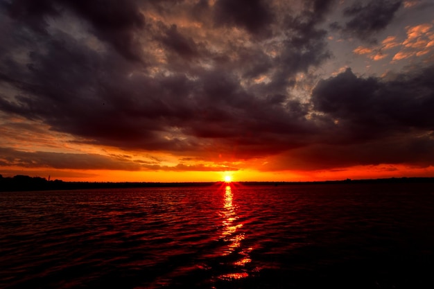 Beau coucher de soleil sur le lac avec nuages et rayons de soleil