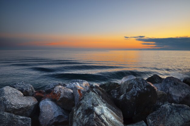 beau coucher de soleil sur la mer avec cadre de pierres colorées